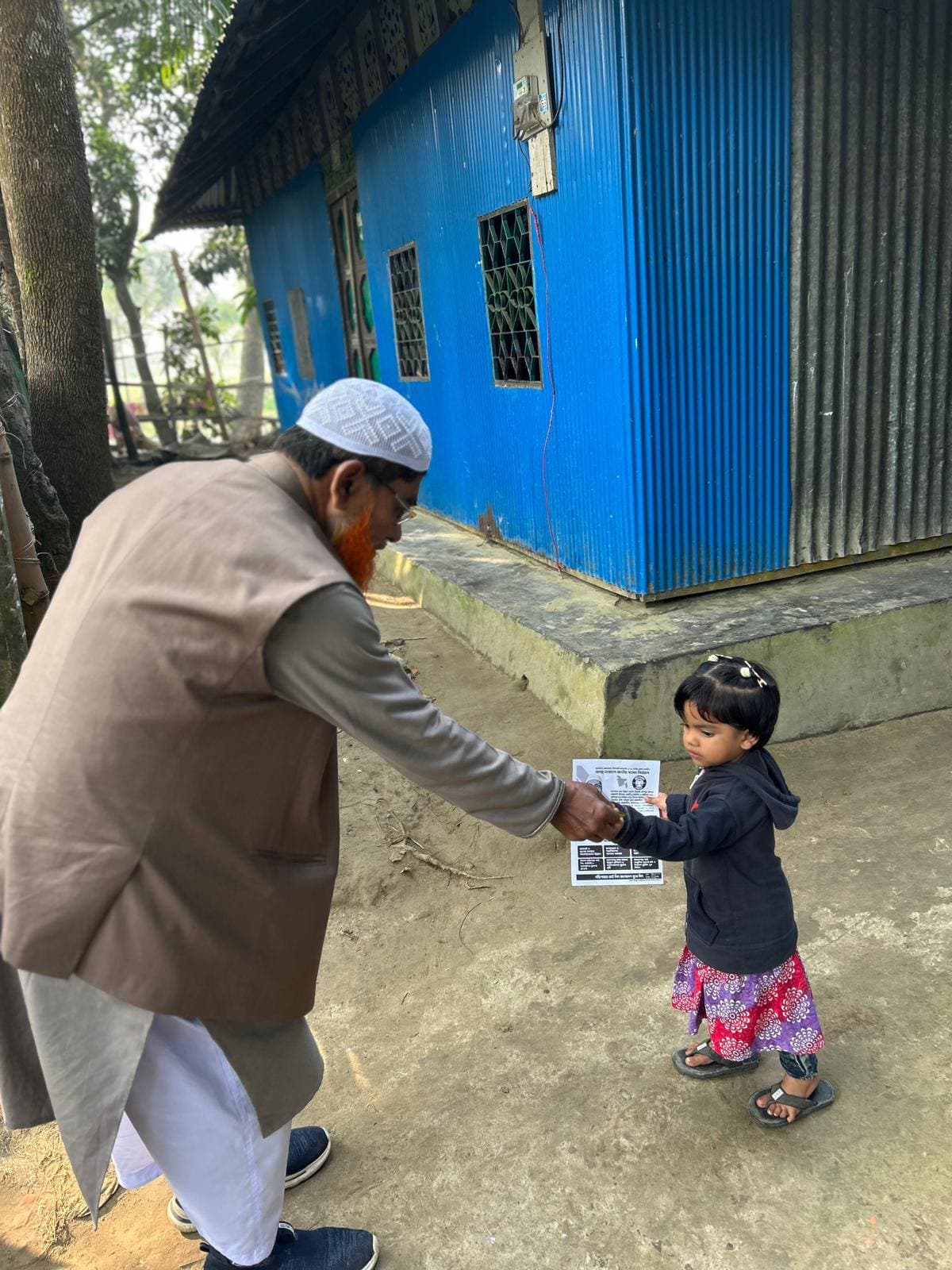 প্রত্যন্ত গ্রামে এককজন শিশুর সঙ্গে হাত মিলাচ্ছেন মাওলানা বিল্লাল হোসেন মিয়াজী