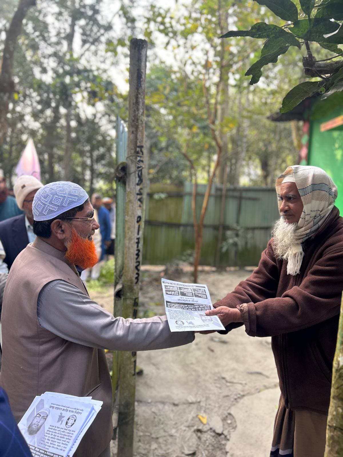 লিফলেট নিয়ে গ্রামে ভোটারদের মাঝে বিল্লাল হোসেন মিয়াজী